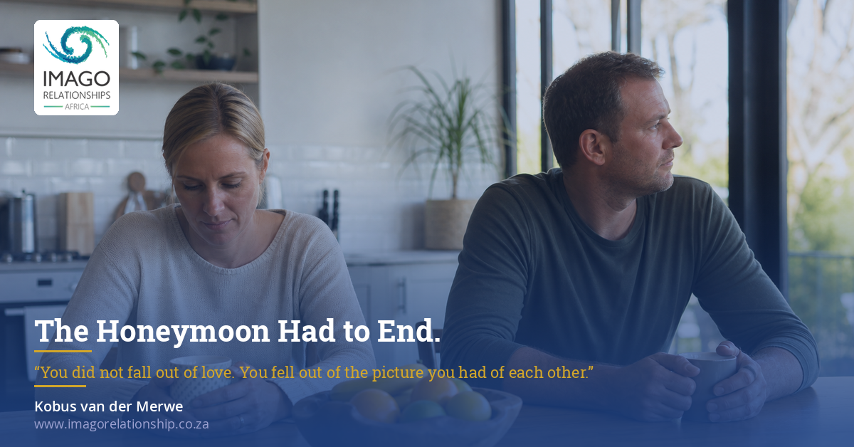 Couple sitting apart at a kitchen counter, looking away from each other.